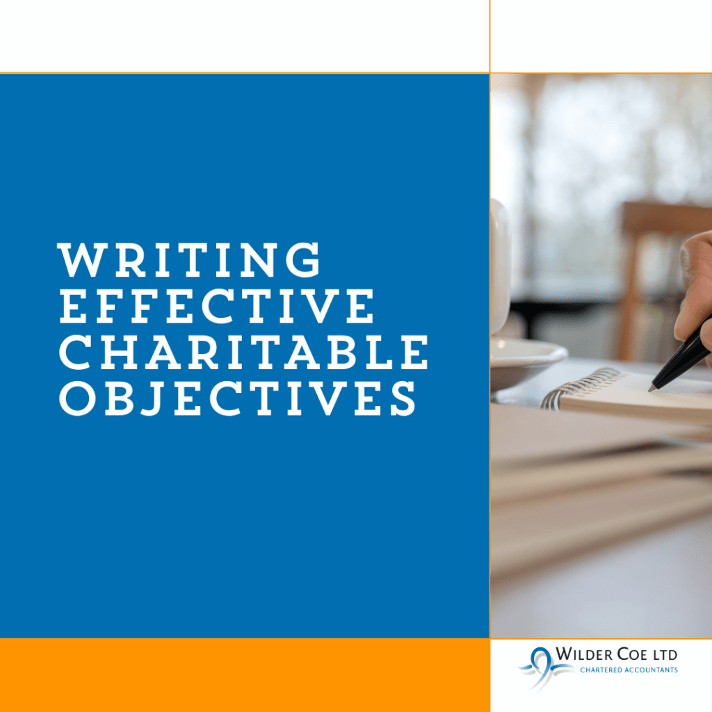 Writing charitable objectives in white font on a blue background next to an image of a notepad and pen